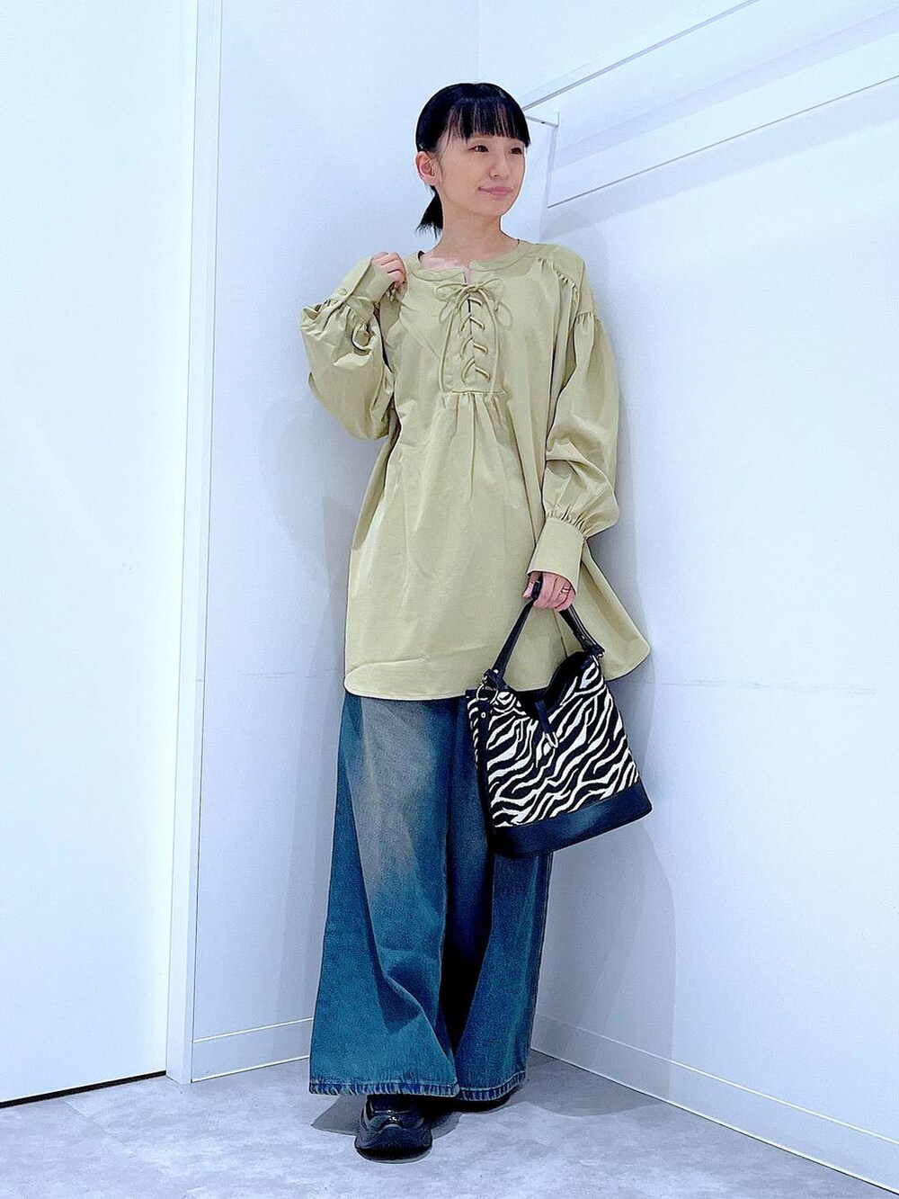 ブラック系のローファー、その他のショルダーバッグ、ブルー系のデニムパンツを着用したレディースの秋コーディネートの2枚目の写真