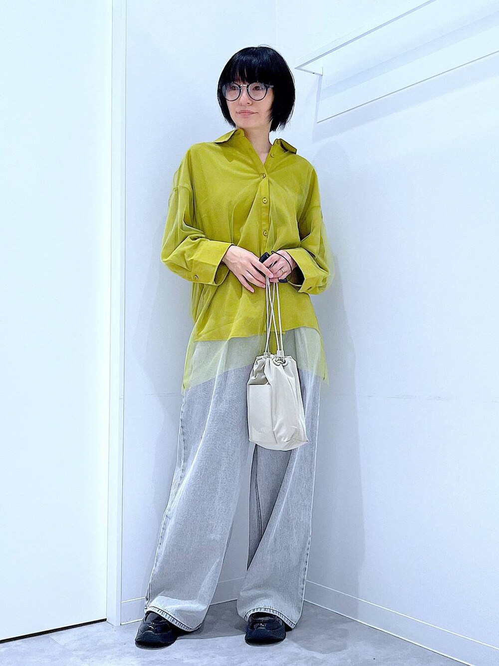 ブラック系のローファー、ベージュ系のショルダーバッグ、イエロー系のシャツ/ブラウスを着用したレディースの秋コーディネートの2枚目の写真