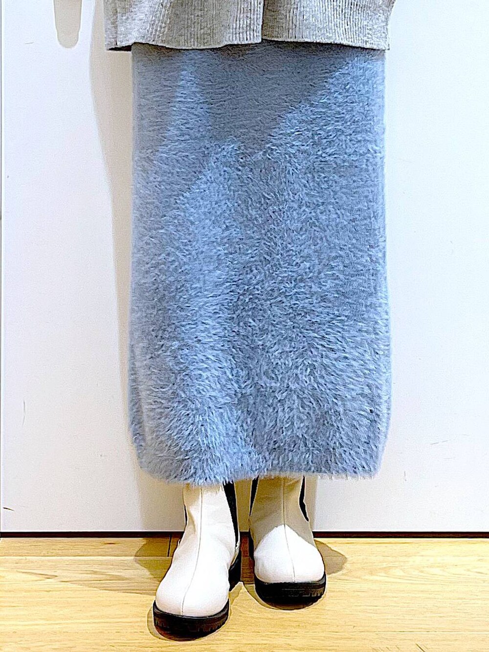 ベージュ系のブーツ、シルバー系のショルダーバッグ、ブルー系のスカートを着用したレディースの冬コーディネートの8枚目の写真