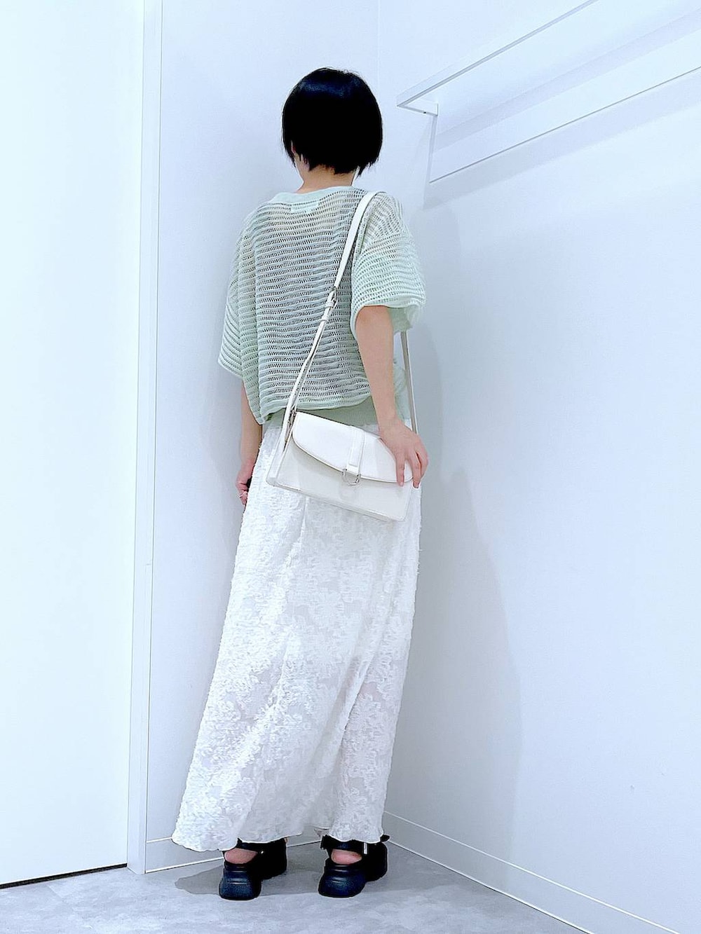 ブラック系のサンダル、ホワイト系のスカート、グリーン系のカーディガン/ボレロを着用したレディースの夏コーディネートの5枚目の写真