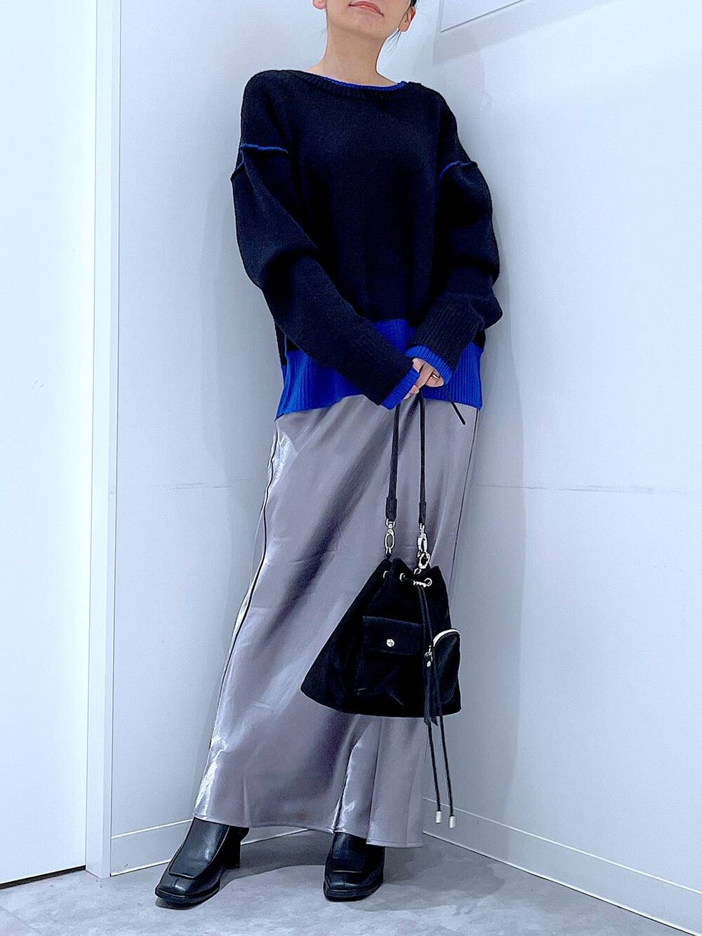 ブラック系のショルダーバッグ、ブラック系のブーツ、ブラック系のニット/セーターを着用したレディースの冬コーディネートの6枚目の写真