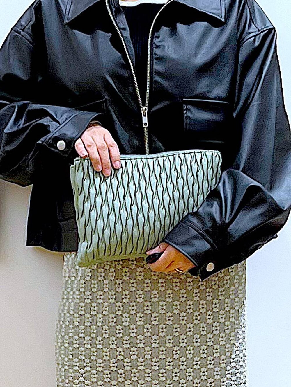 グリーン系のショルダーバッグ、ベージュ系のブーツ、グリーン系のスカートを着用したレディースの春コーディネートの9枚目の写真