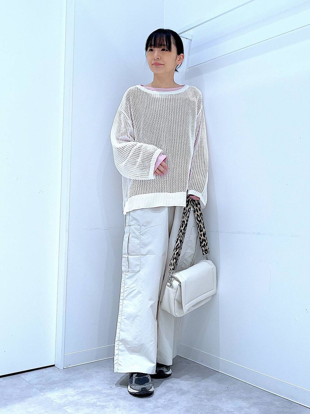 ピンク系のTシャツ/カットソー、ホワイト系のショルダーバッグ、ホワイト系のニット/セーターを着用したレディースの春コーディネートの2枚目の写真