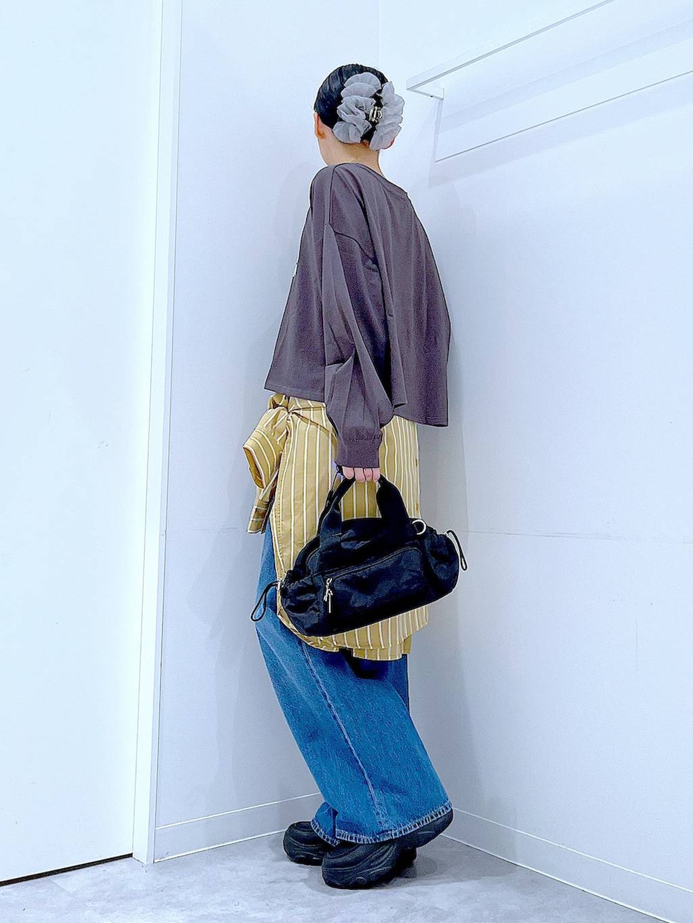 ブルー系のデニムパンツ、イエロー系のシャツ/ブラウス、グレー系のTシャツ/カットソーを着用したレディースの秋コーディネートの3枚目の写真