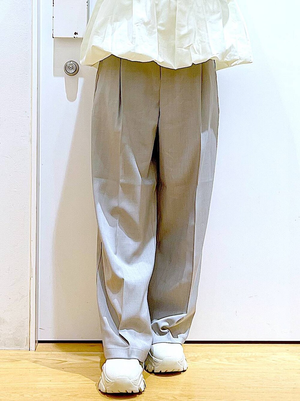 ブラウン系のハンドバッグ、ベージュ系のブーツ、ベージュ系のスウェットを着用したレディースの冬コーディネートの8枚目の写真