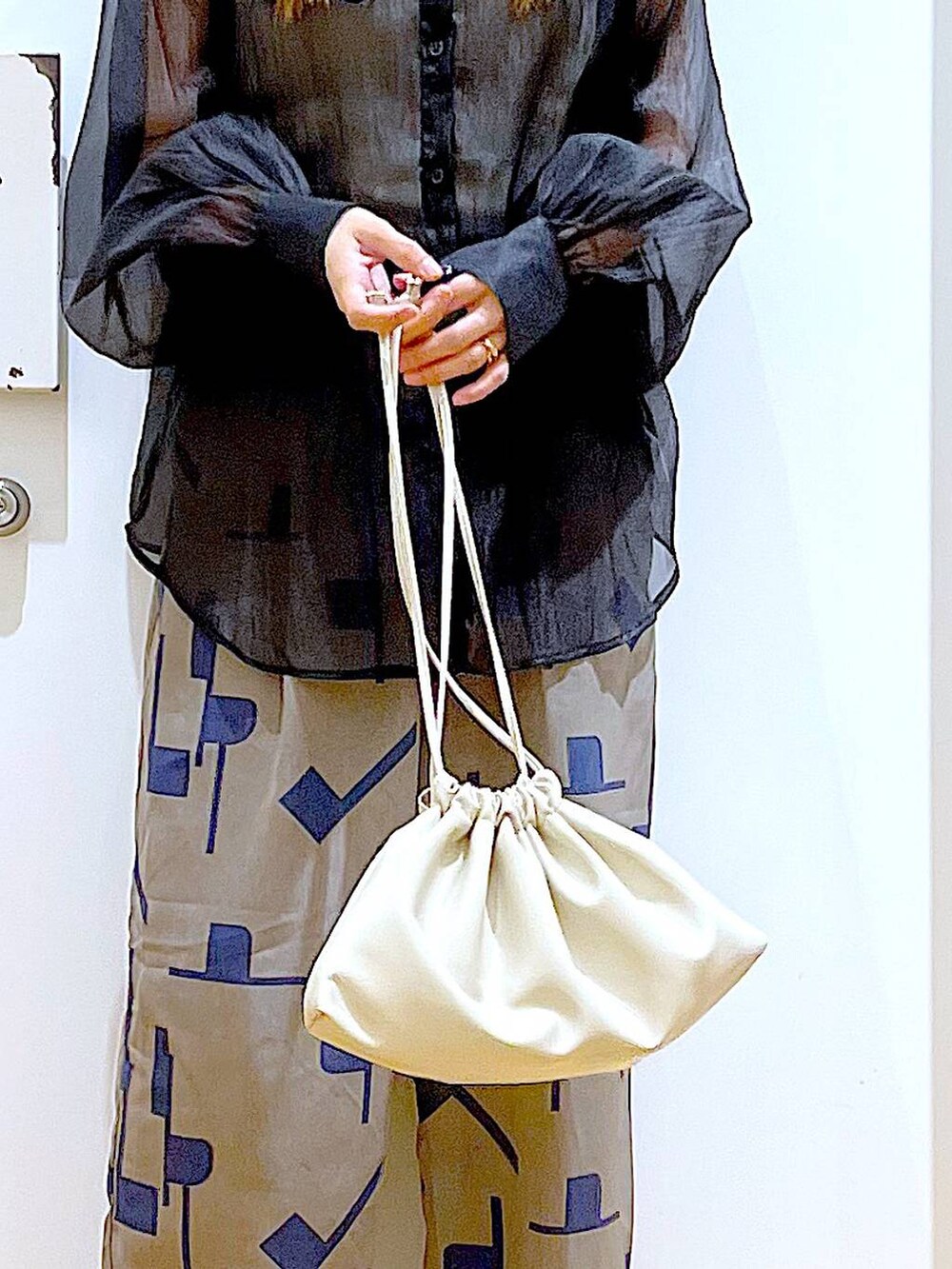 グレー系のその他パンツ、ブラック系のシャツ/ブラウス、ベージュ系のショルダーバッグを着用したレディースの春コーディネートの9枚目の写真