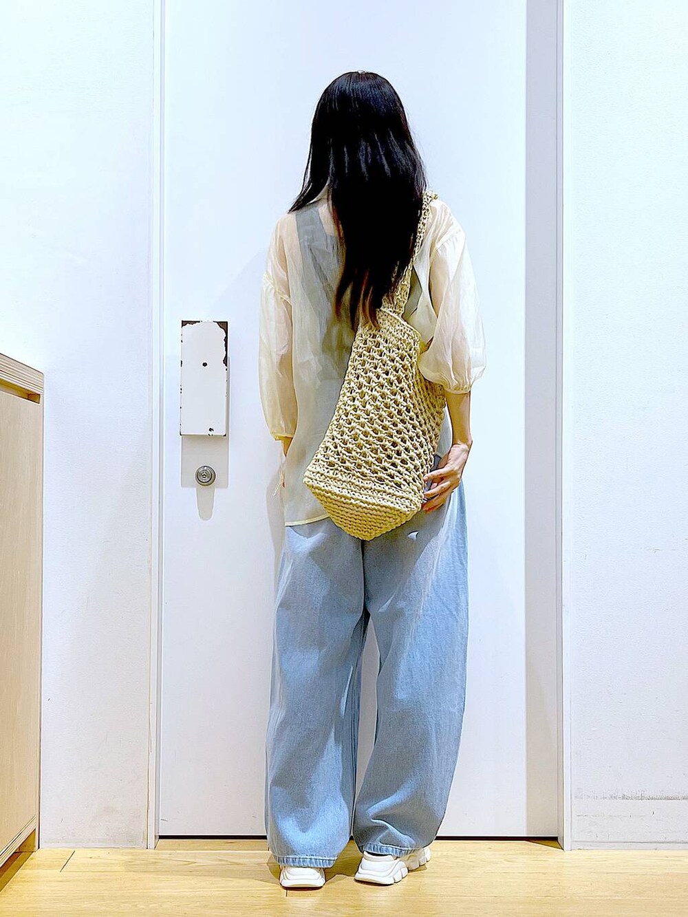 ホワイト系のサンダル、ホワイト系のトートバッグ、ブルー系のデニムパンツを着用したレディースの夏コーディネートの5枚目の写真