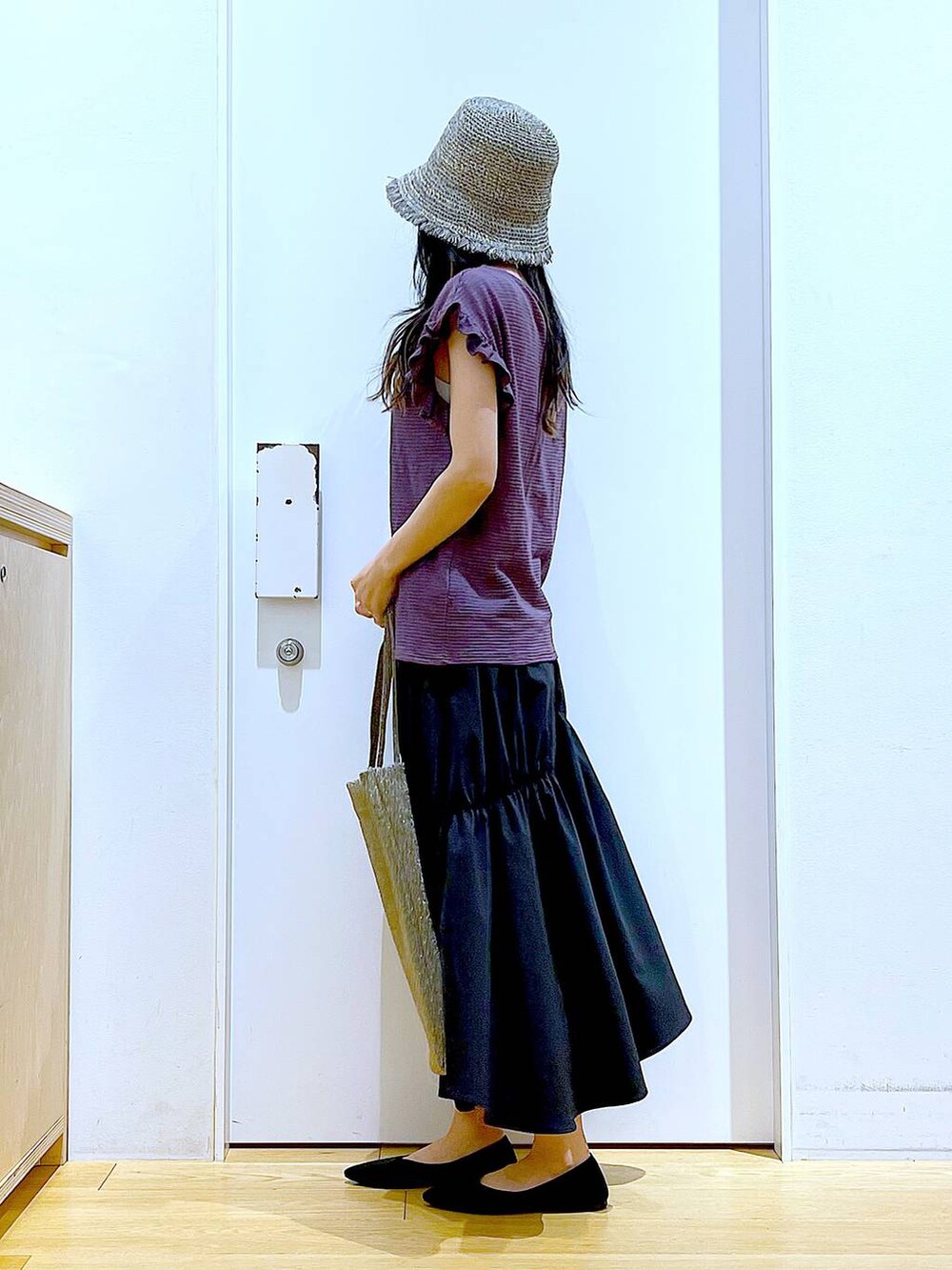 ブラック系のパンプス、ブラウン系のTシャツ/カットソー、ブラック系のスカートを着用したレディースの夏コーディネートの3枚目の写真