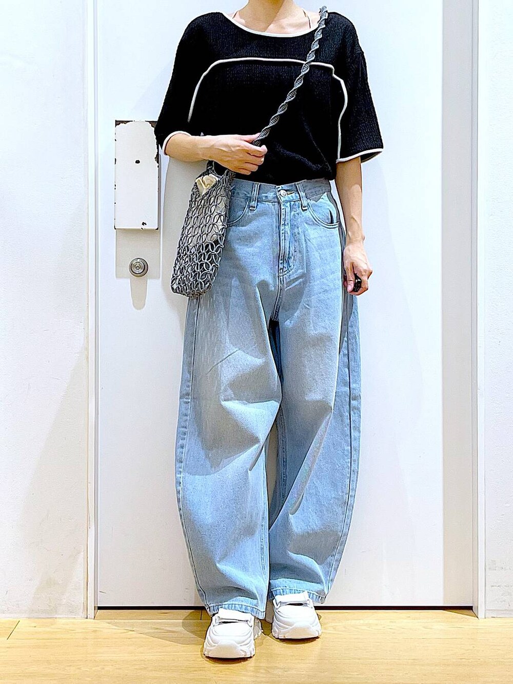 ホワイト系のスニーカー、ブルー系のデニムパンツ、グレー系のショルダーバッグを着用したレディースの夏コーディネートの6枚目の写真