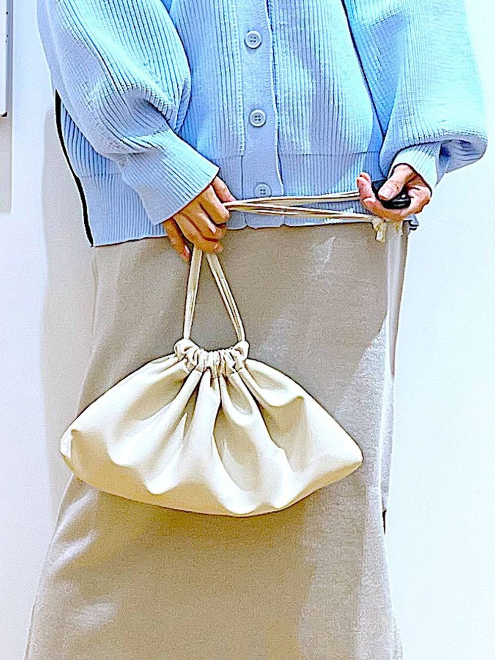 グレー系のスカート、その他のニット/セーター、ベージュ系のブーツを着用したレディースの春コーディネートの9枚目の写真