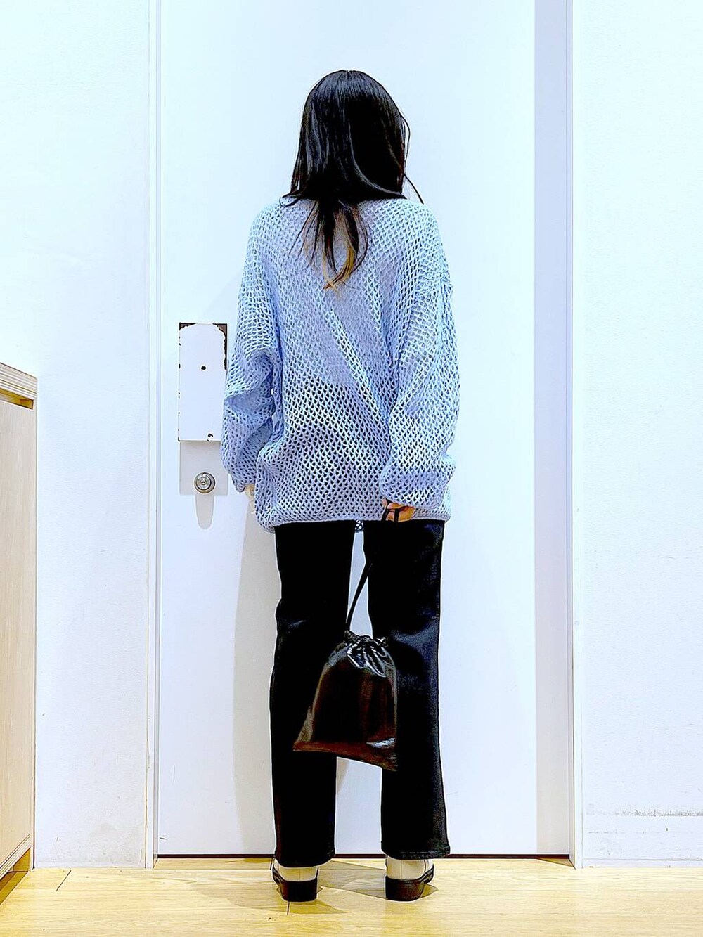 グレー系のデニムパンツ、ホワイト系のTシャツ/カットソー、ブルー系のニット/セーターを着用したレディースの冬コーディネートの5枚目の写真