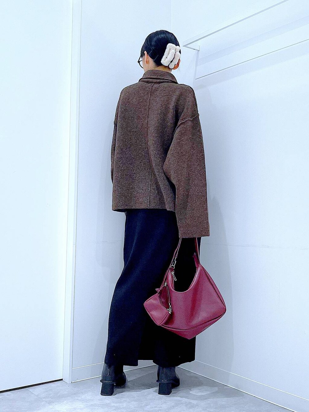 ブラウン系のブルゾン、ブラック系のブーツ、レッド系のショルダーバッグを着用したレディースの秋コーディネートの5枚目の写真