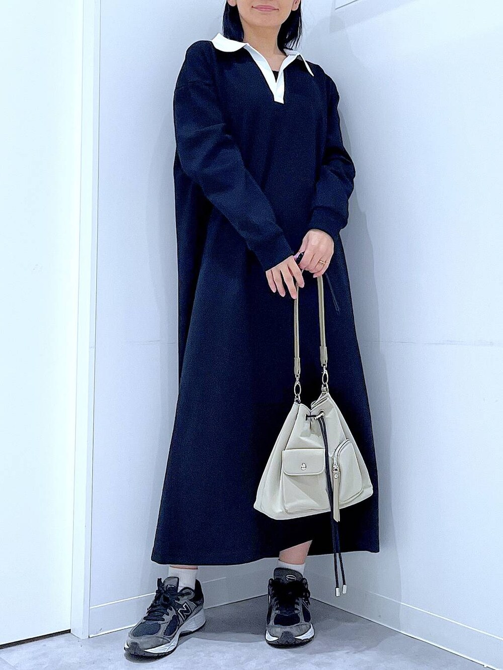 ホワイト系のショルダーバッグ、ブラック系のワンピース、ホワイト系のキャップを着用したレディースの春コーディネートの6枚目の写真