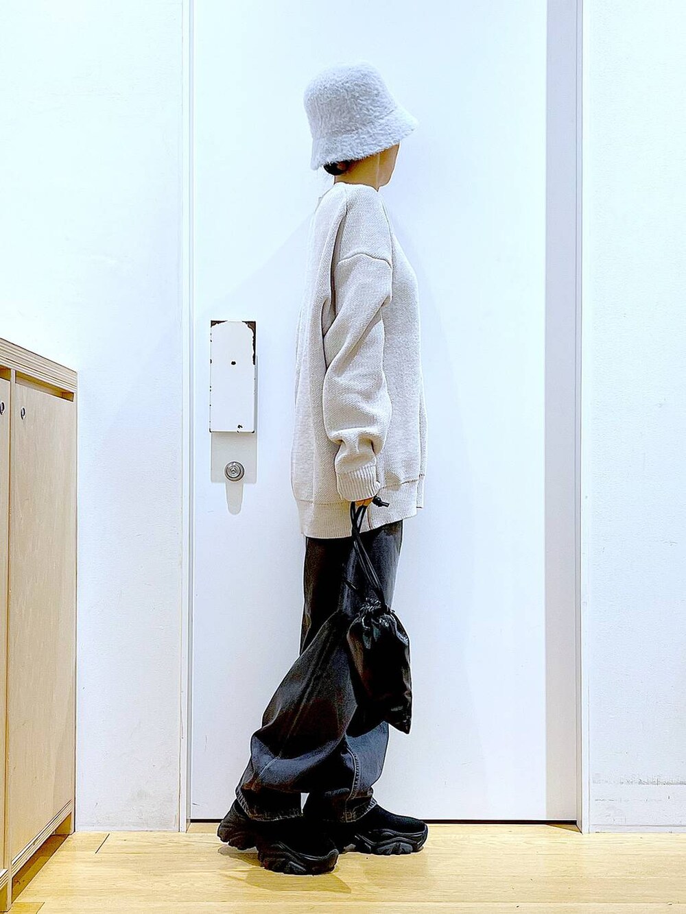 ブラック系のブーツ、ベージュ系のニット/セーター、ブルー系のデニムパンツを着用したレディースの冬コーディネートの4枚目の写真