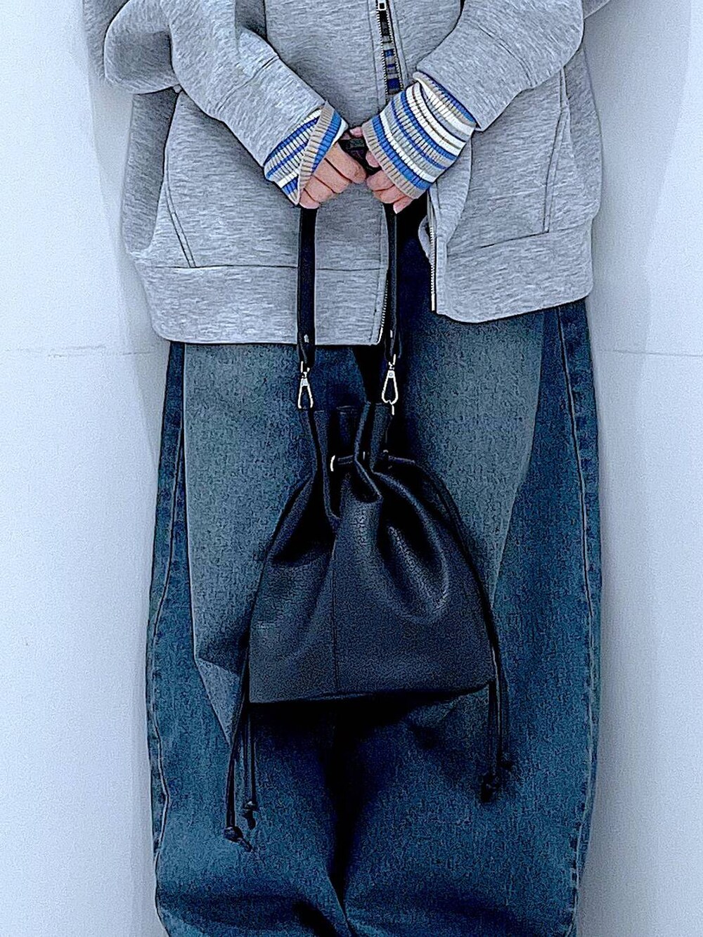 ブルー系のデニムパンツ、グレー系のパーカー、ブラック系のショルダーバッグを着用したレディースの冬コーディネートの9枚目の写真