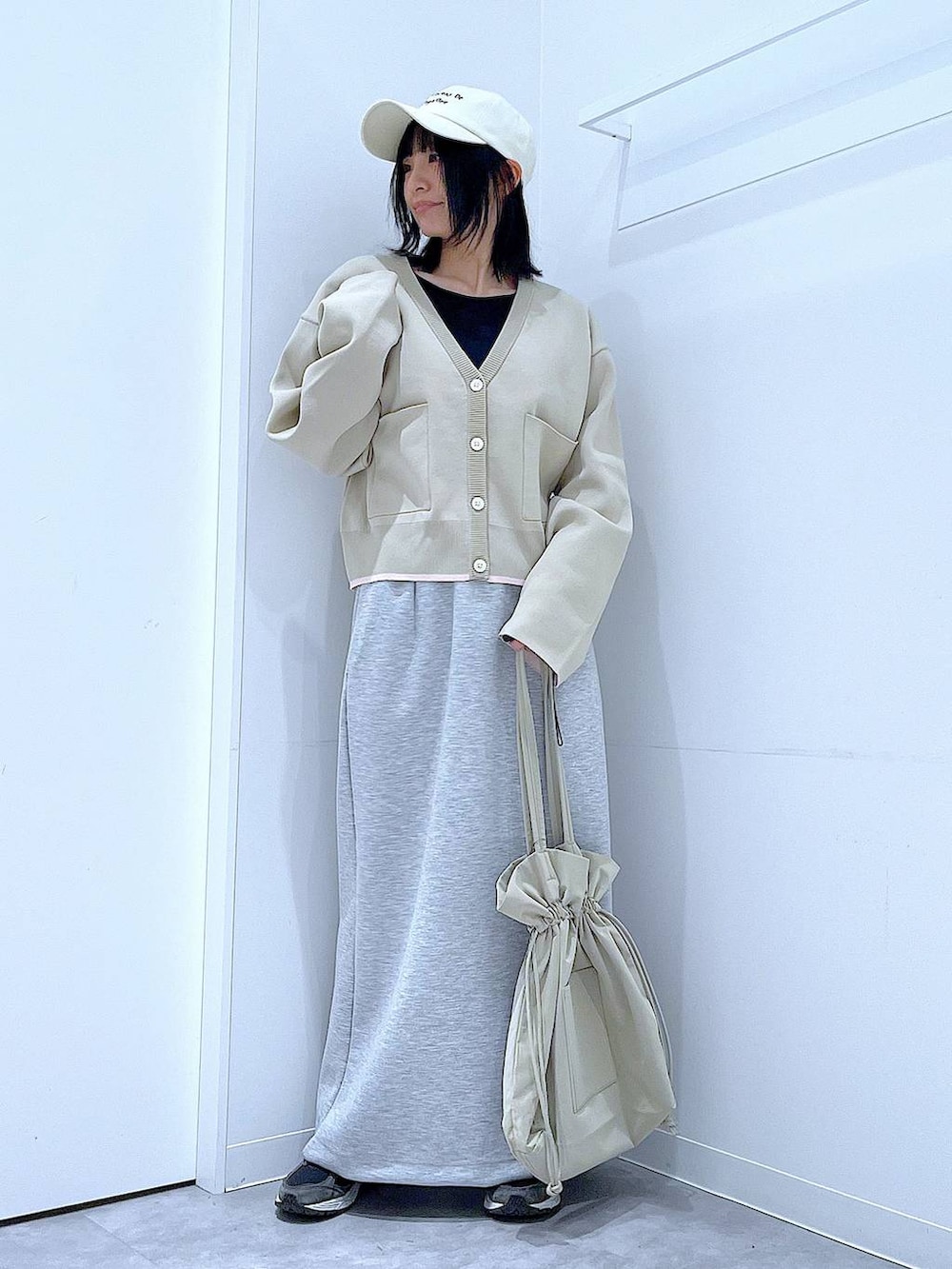 ブラック系のTシャツ/カットソー、ベージュ系のトートバッグ、グレー系のスカートを着用したレディースの冬コーディネートの2枚目の写真