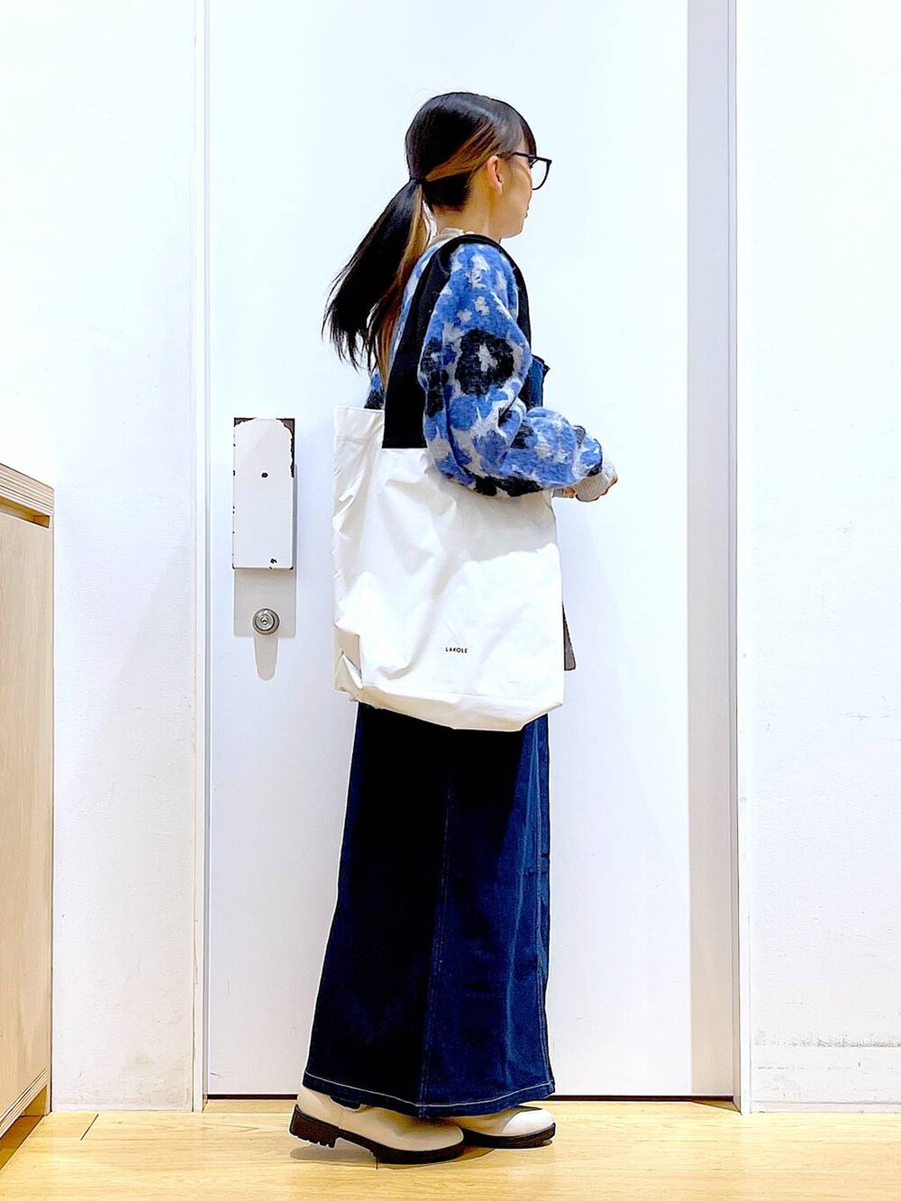 ブルー系のジャンパースカート、ホワイト系のTシャツ/カットソー、ベージュ系のブーツを着用したレディースの冬コーディネートの4枚目の写真