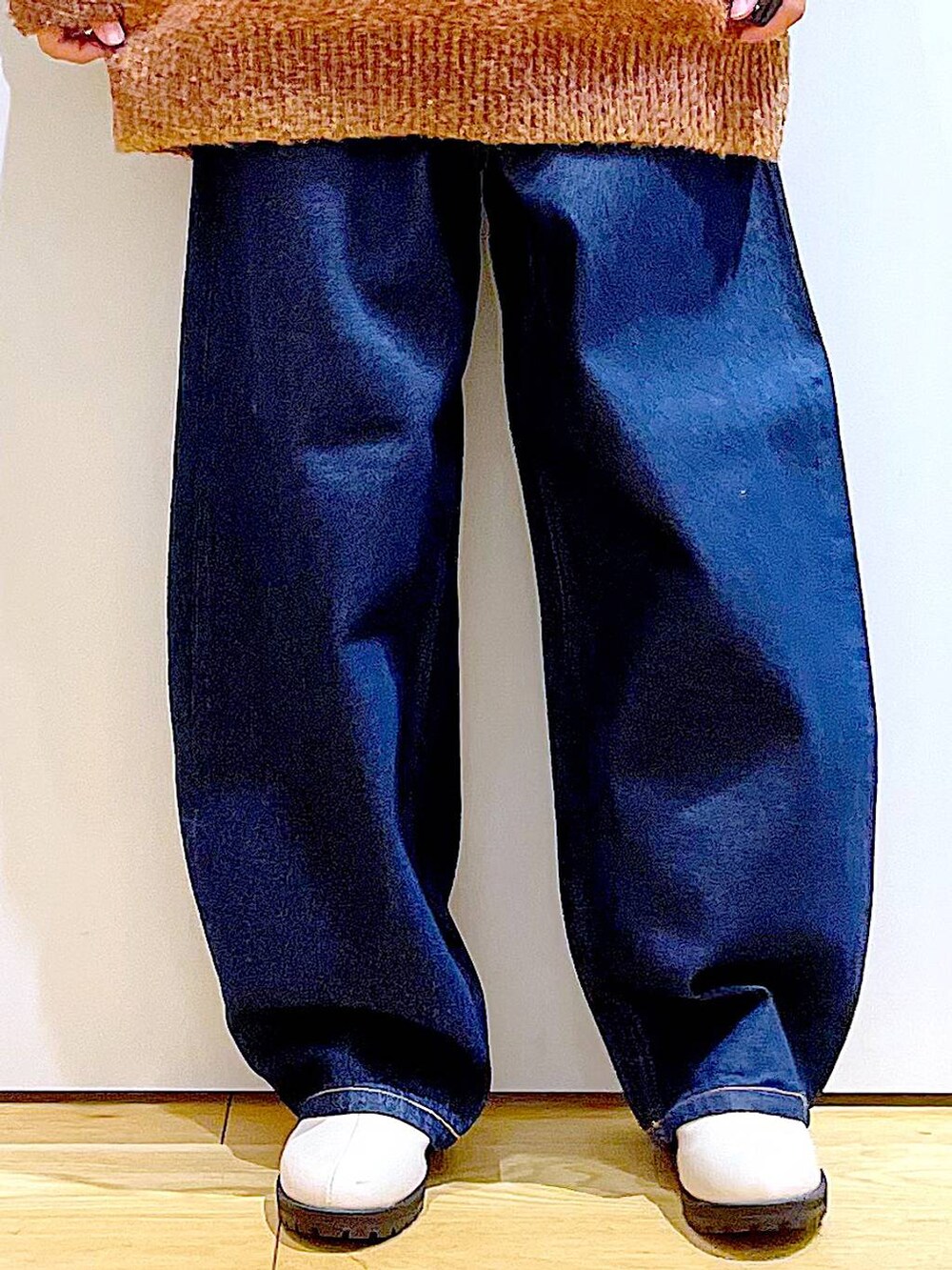 オレンジ系のニット/セーター、ホワイト系のトートバッグ、ベージュ系のブーツを着用したレディースの冬コーディネートの8枚目の写真