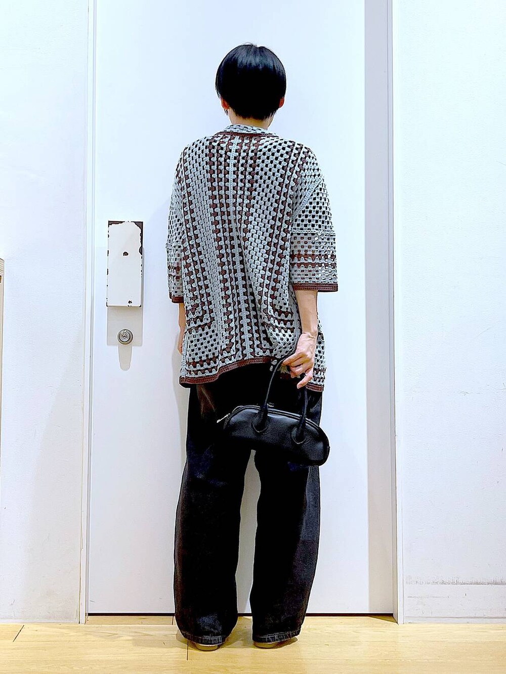 ブラック系のデニムパンツ、ブラック系のボストンバッグ、シルバー系のパンプスを着用したレディースの夏コーディネートの5枚目の写真