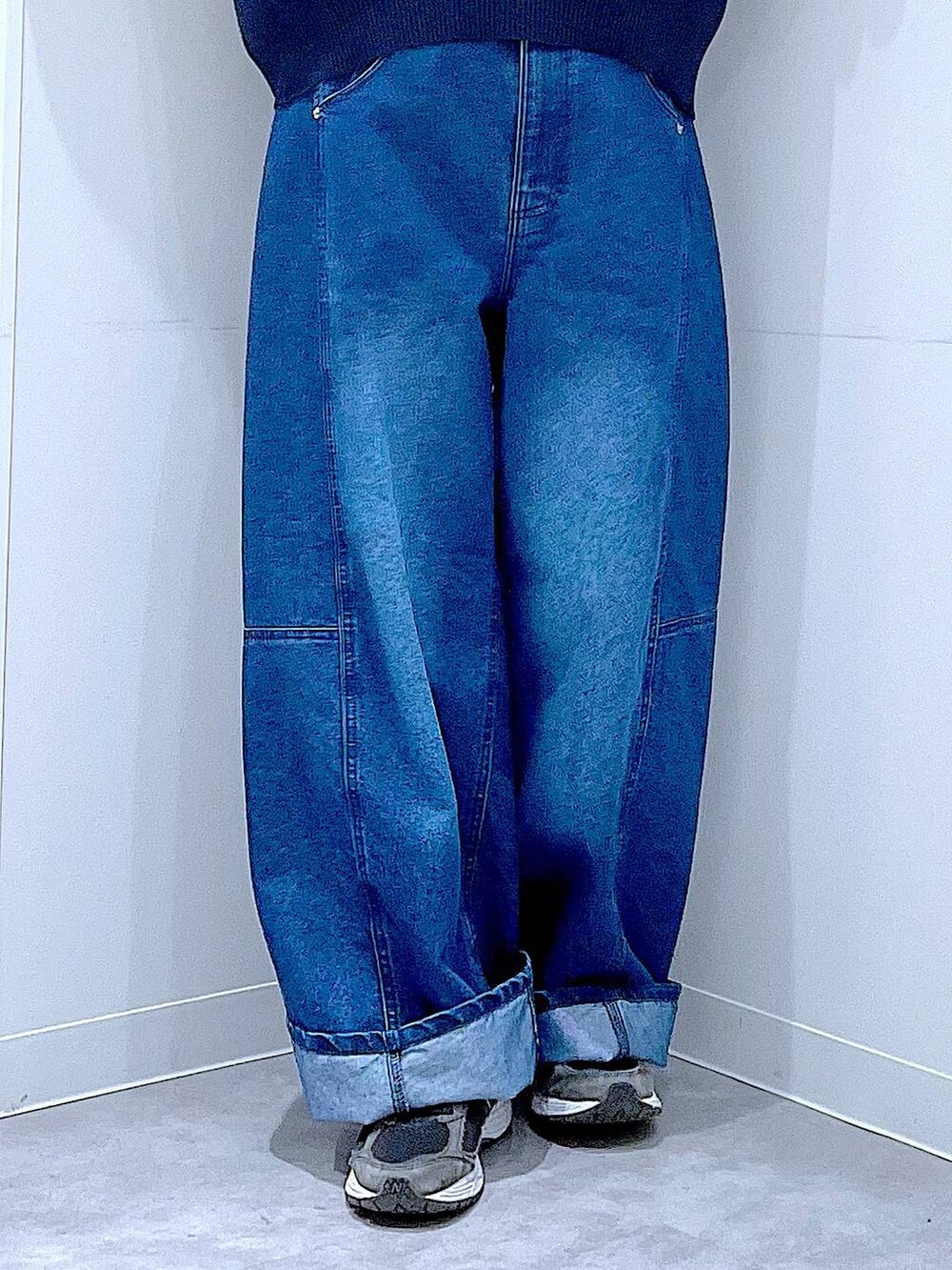 グリーン系のトートバッグ、ブルー系のニット/セーター、ブルー系のデニムパンツを着用したレディースの冬コーディネートの8枚目の写真