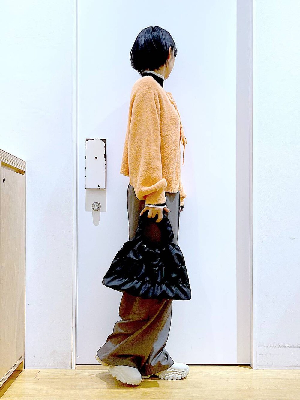 ブラック系のニット/セーター、ベージュ系のブーツ、ブラック系のショルダーバッグを着用したレディースの冬コーディネートの4枚目の写真