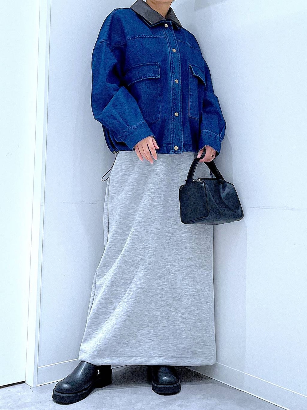 ブラック系のショルダーバッグ、グレー系のスカート、ブラック系のサンダルを着用したレディースの春コーディネートの6枚目の写真