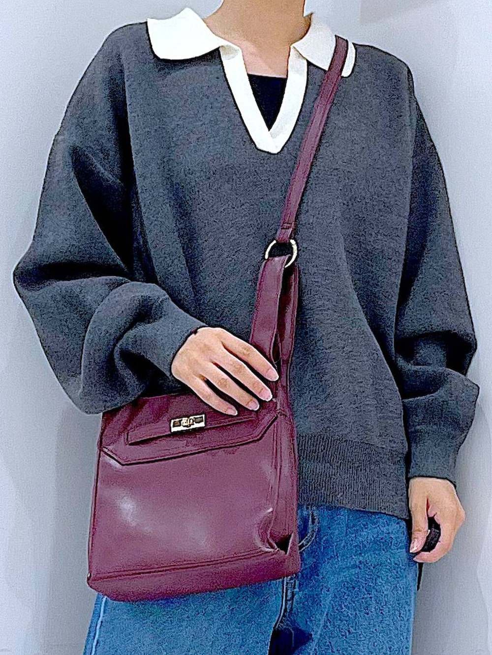 ブルー系のデニムパンツ、レッド系のショルダーバッグ、グレー系のニット/セーターを着用したレディースの秋コーディネートの9枚目の写真
