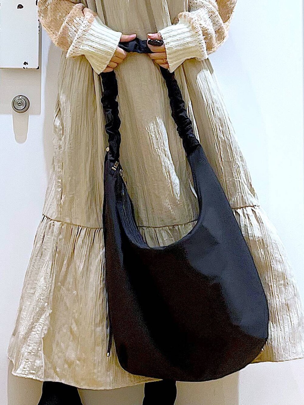 ブラック系のショルダーバッグ、ブラック系のブーツ、ベージュ系のワンピースを着用したレディースの冬コーディネートの9枚目の写真