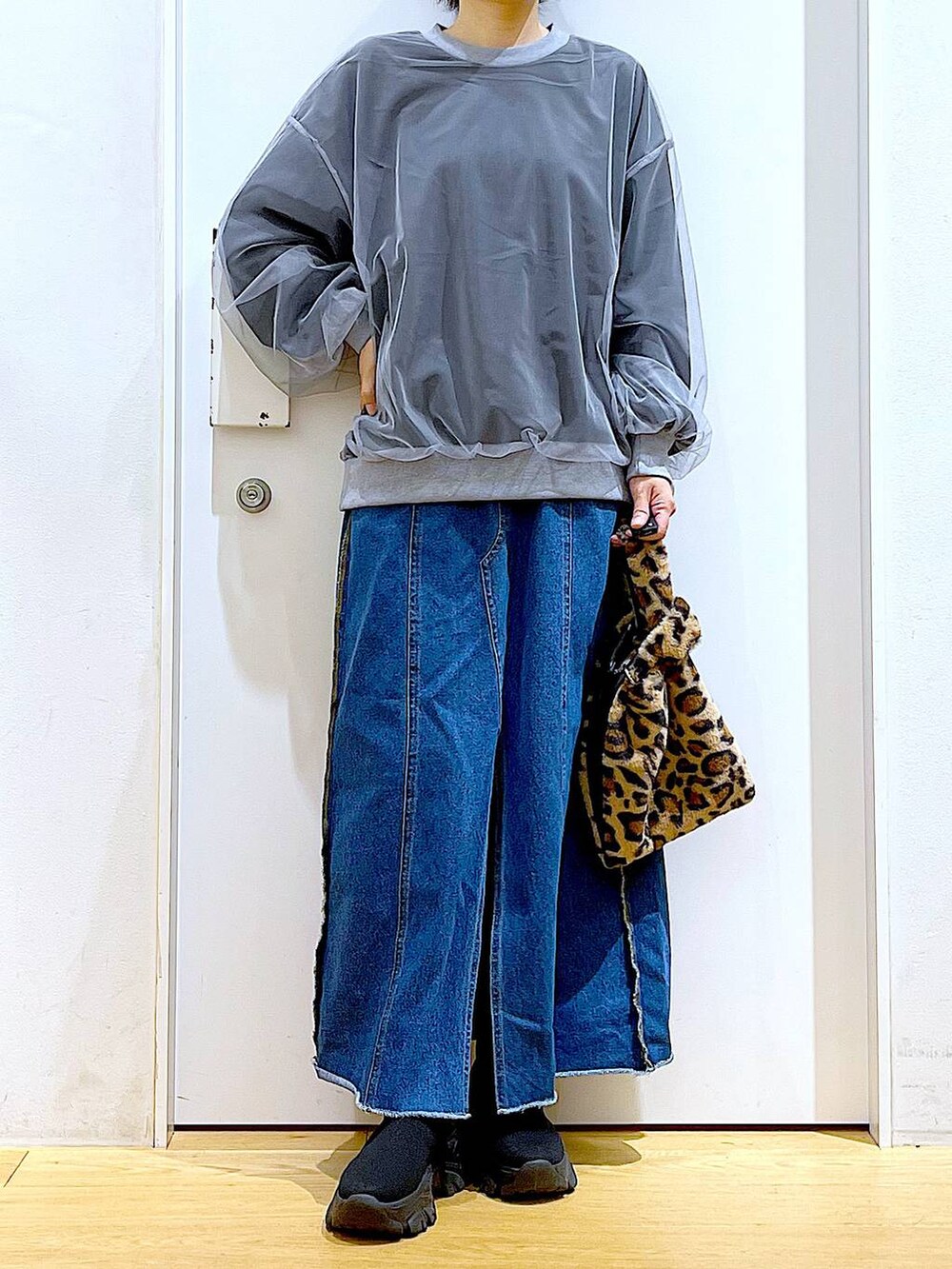 その他のショルダーバッグ、ブルー系のデニムスカート、ブラック系のブーツを着用したレディースの冬コーディネートの6枚目の写真