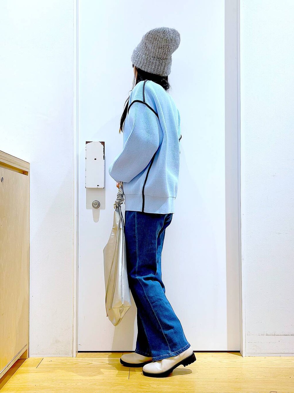 ブルー系のデニムパンツ、ベージュ系のブーツ、ベージュ系のニット/セーターを着用したレディースの冬コーディネートの3枚目の写真