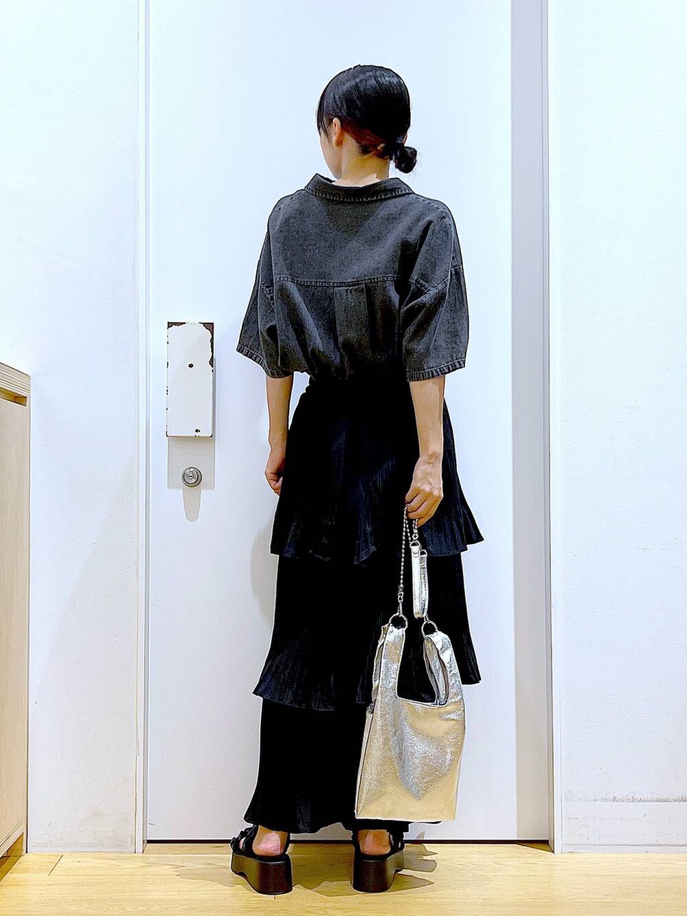 シルバー系のショルダーバッグ、ブラック系のスカート、ブラック系のサンダルを着用したレディースの夏コーディネートの5枚目の写真