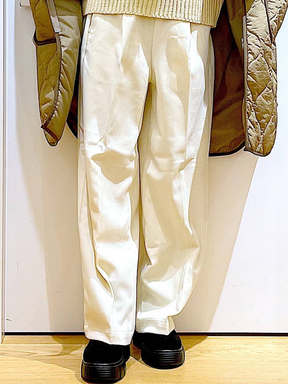 グリーン系のナイロンジャケット、ベージュ系のショルダーバッグ、ブラック系のブーツを着用したレディースの冬コーディネートの8枚目の写真