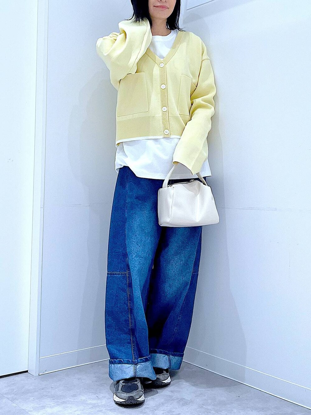 ホワイト系のショルダーバッグ、ホワイト系のTシャツ/カットソー、ブルー系のデニムパンツを着用したレディースの春コーディネートの6枚目の写真