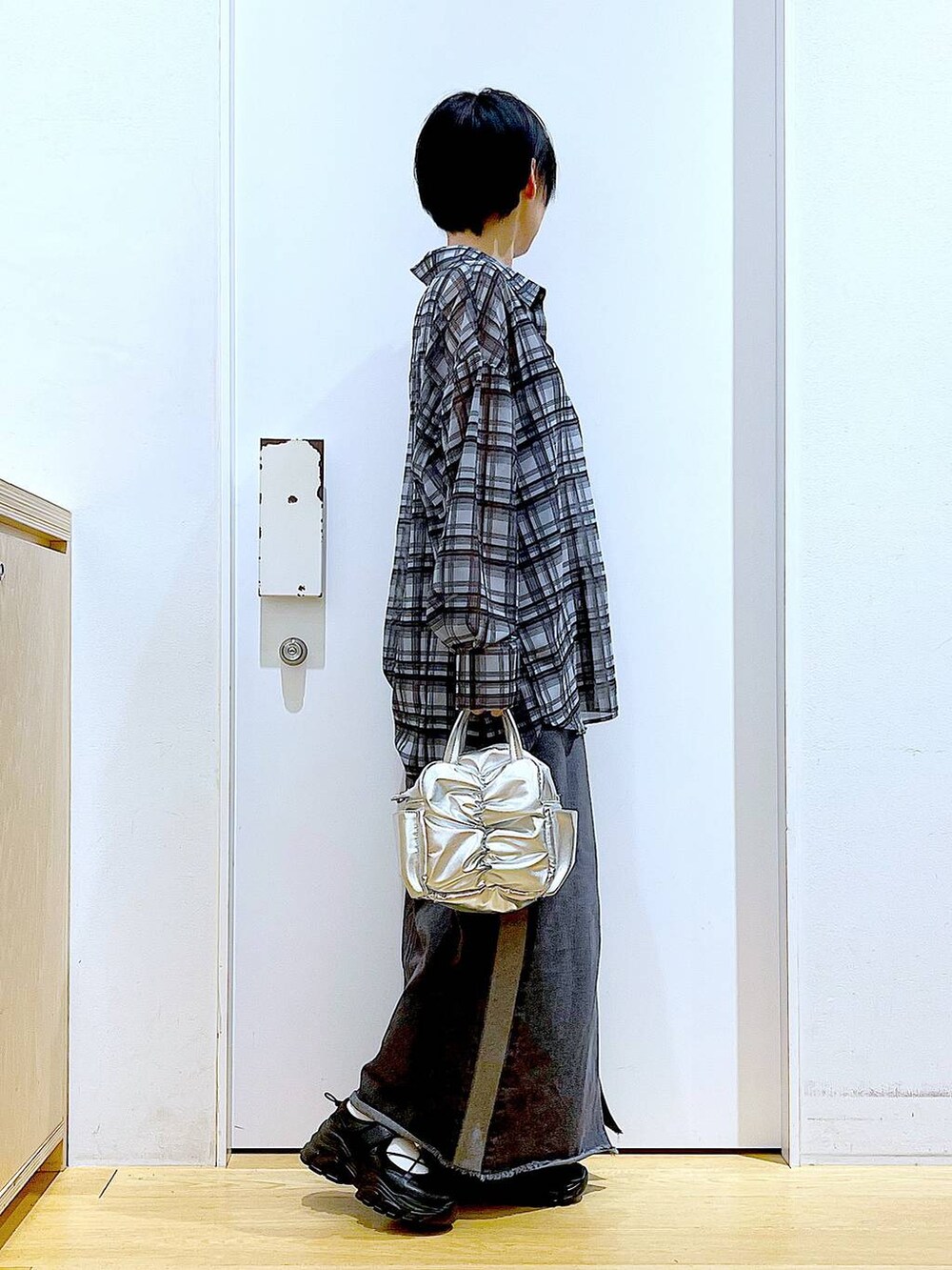 ブラック系のスニーカー、ブラック系のデニムスカート、グレー系のシャツ/ブラウスを着用したレディースの春コーディネートの4枚目の写真