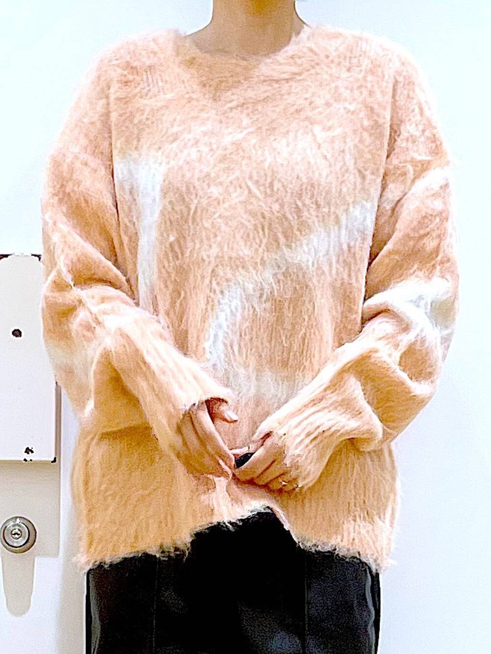 ピンク系のニット/セーター、ブラック系のブーツ、ブラック系のショルダーバッグを着用したレディースの冬コーディネートの7枚目の写真