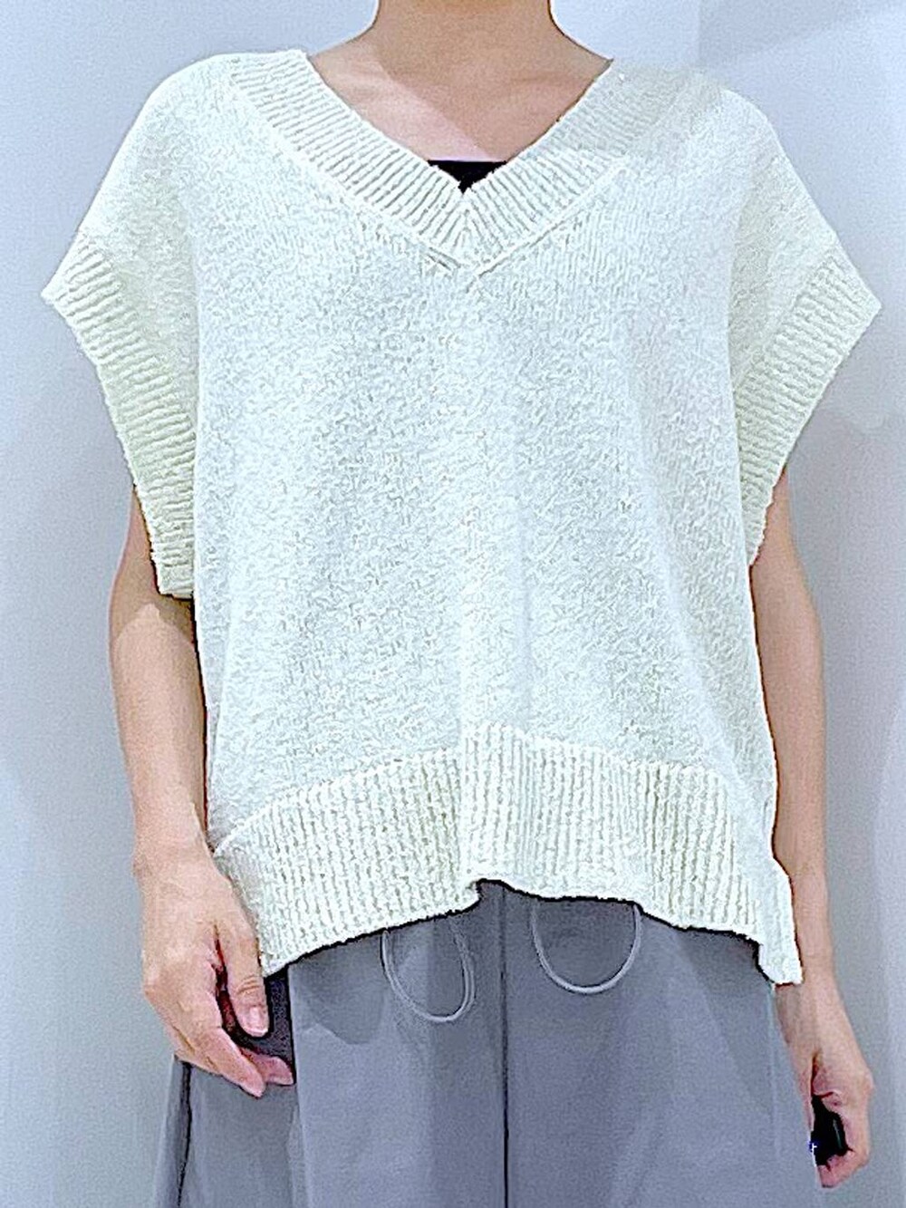 シルバー系のサンダル、グレー系のスカート、ホワイト系のベストを着用したレディースの夏コーディネートの7枚目の写真