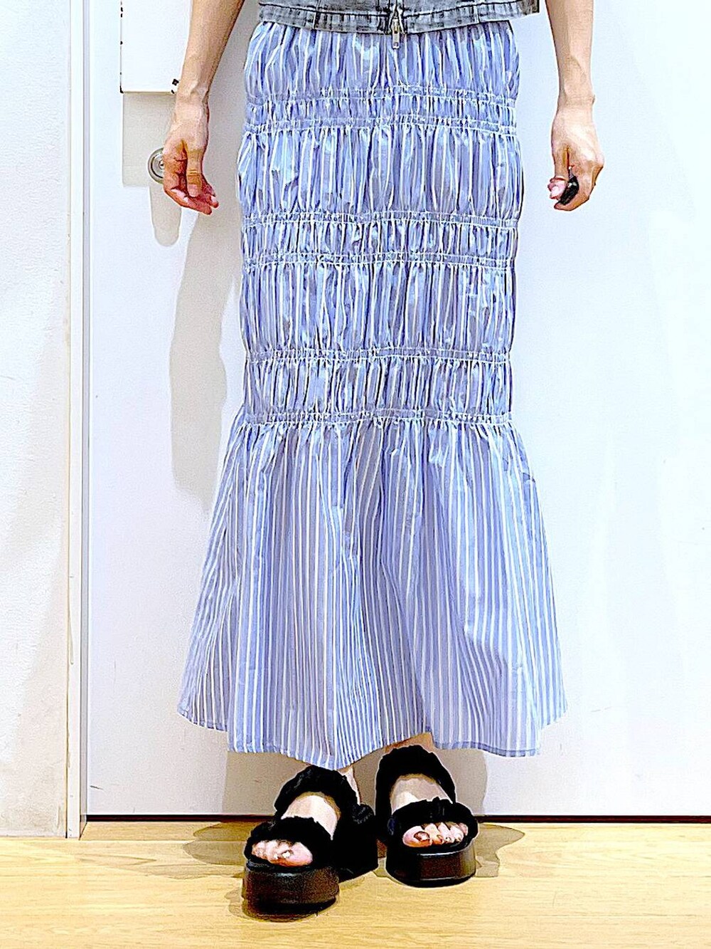 ブラック系のサンダル、ブラック系のトートバッグ、グレー系のベストを着用したレディースの夏コーディネートの8枚目の写真