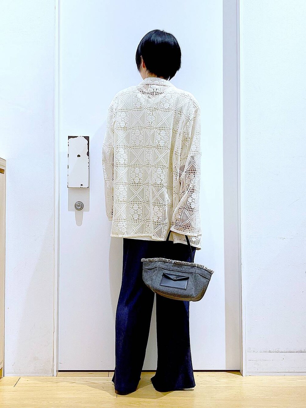 ブラック系のパンプス、ブラック系のショルダーバッグ、ホワイト系のテーラードジャケットを着用したレディースの春コーディネートの5枚目の写真