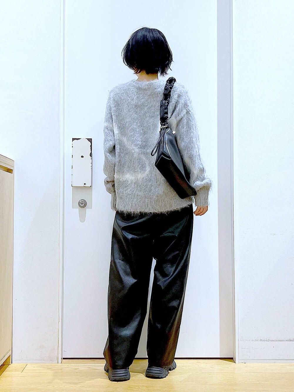 グレー系のニット/セーター、ブラック系のブーツ、ブラック系のその他パンツを着用したレディースの冬コーディネートの5枚目の写真