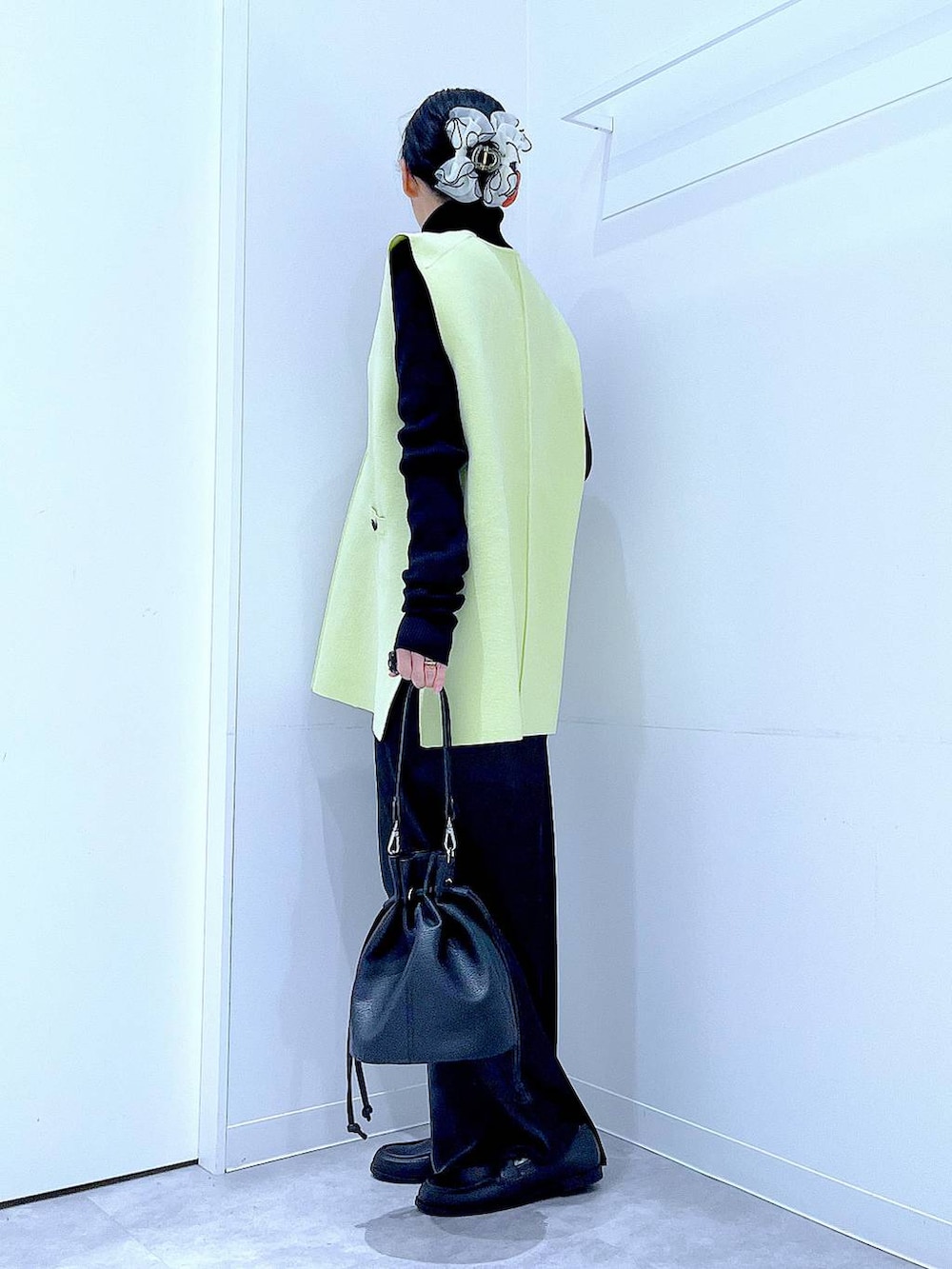 ブラック系のニット/セーター、ブラック系のスカート、ブラック系のローファーを着用したレディースの春コーディネートの3枚目の写真