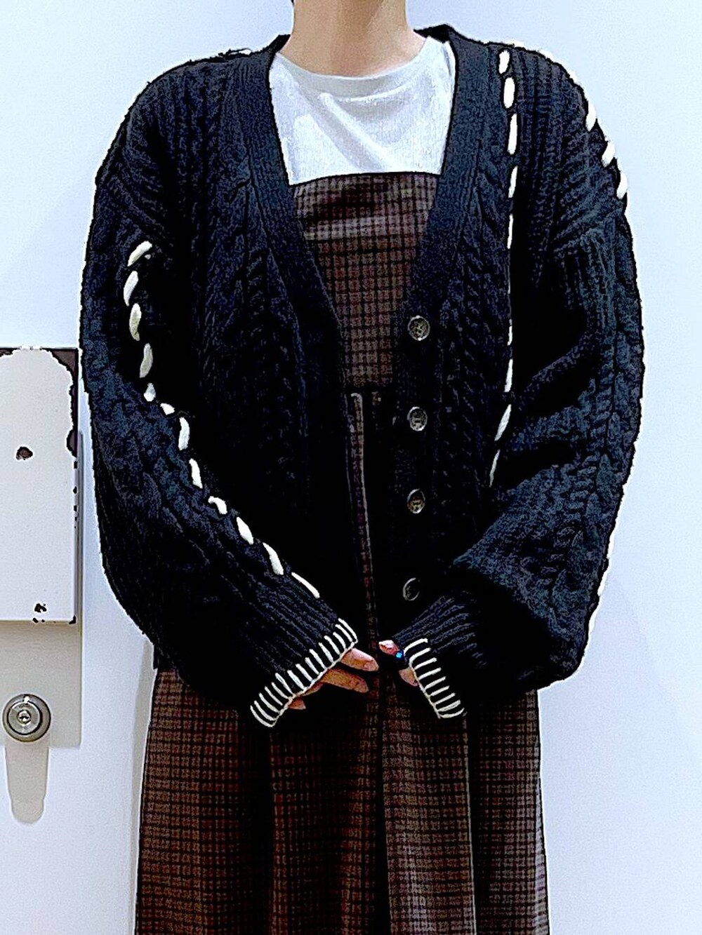 ブラック系のブーツ、ピンク系のショルダーバッグ、ブラック系のカーディガン/ボレロを着用したレディースの冬コーディネートの7枚目の写真