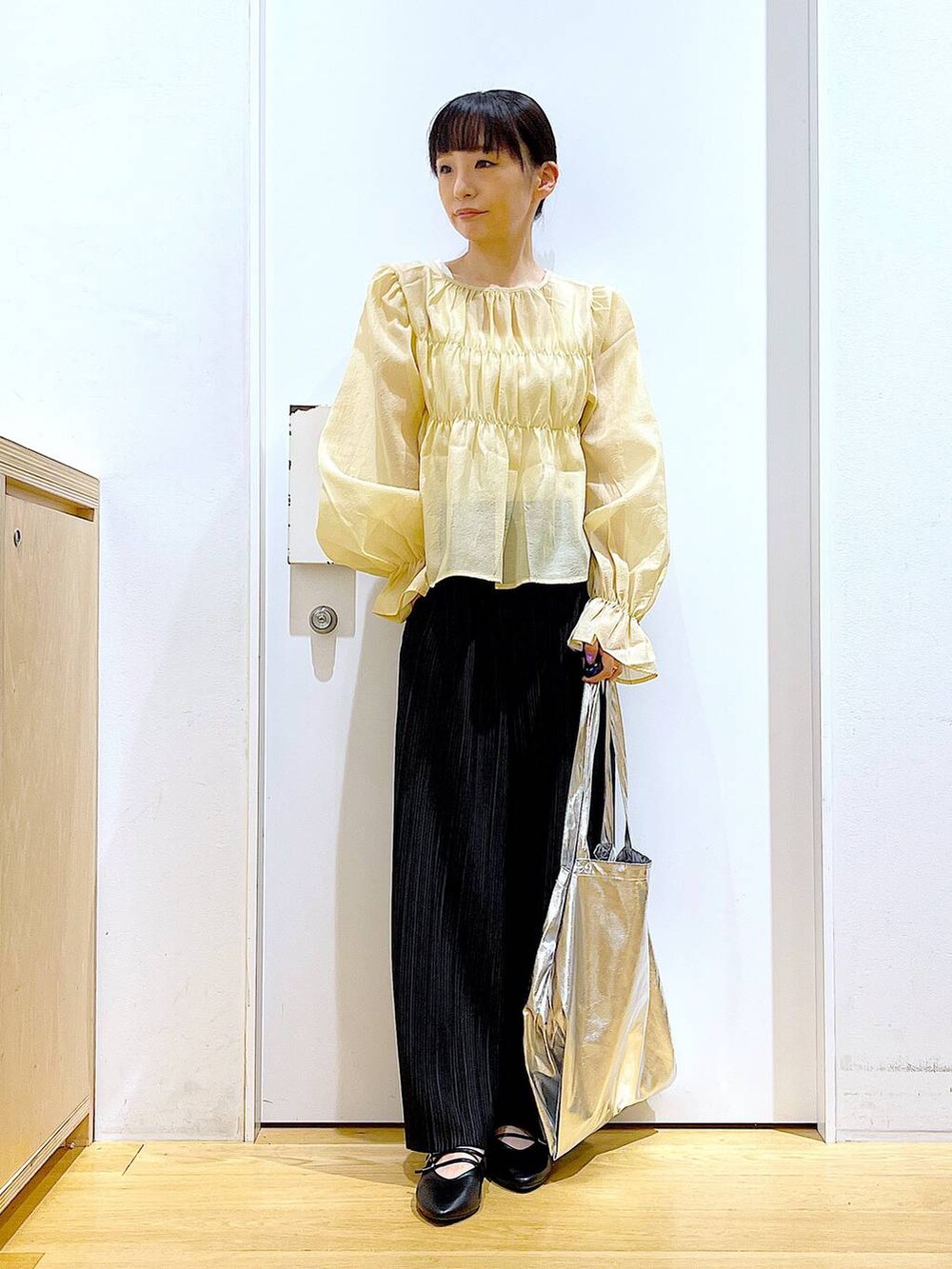 シルバー系のトートバッグ、ブラック系のその他パンツ、ブラック系のパンプスを着用したレディースの秋コーディネートの2枚目の写真