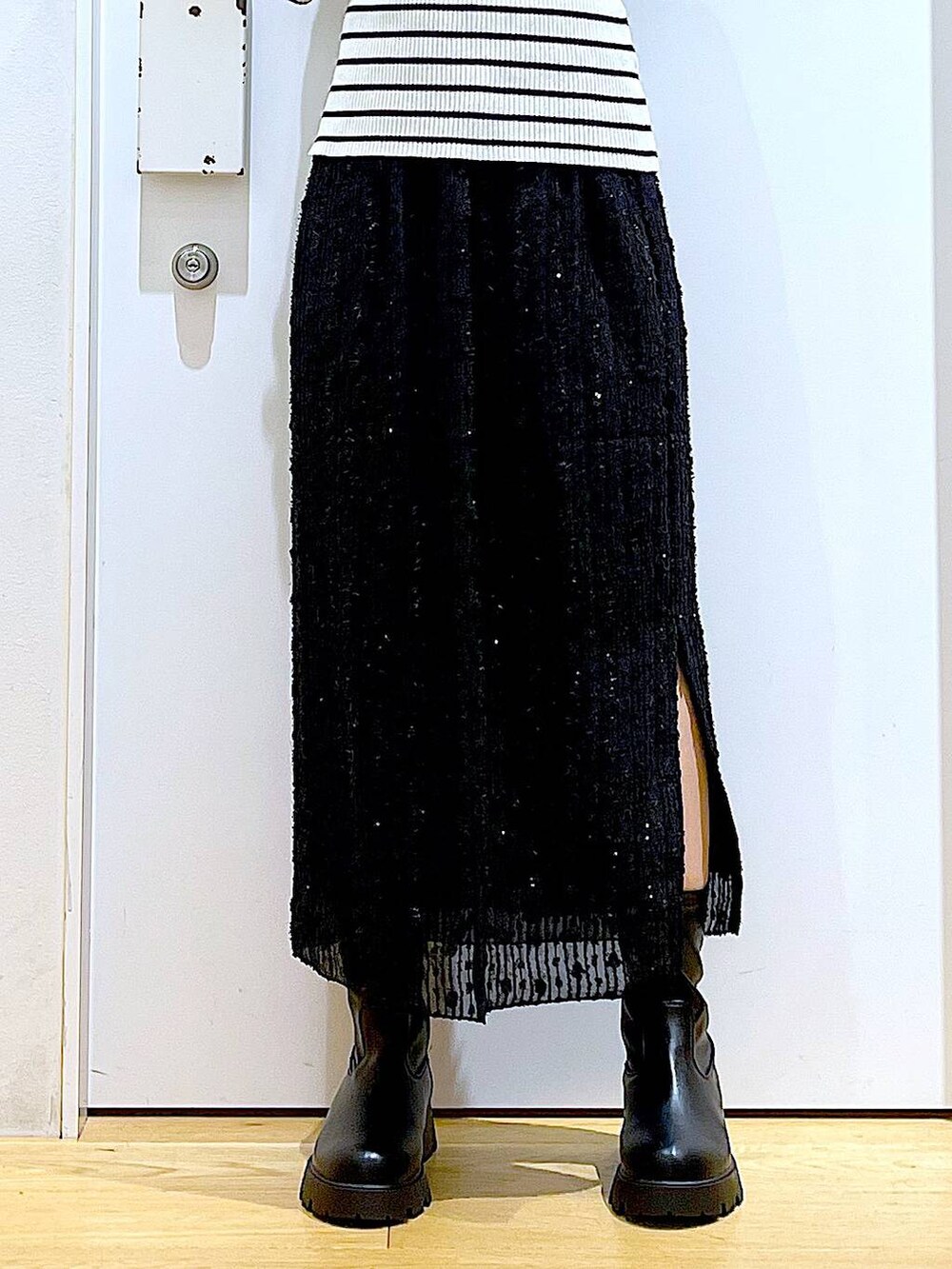 ホワイト系のニット/セーター、ブラック系のハンドバッグ、ブラック系のブーツを着用したレディースの秋コーディネートの8枚目の写真