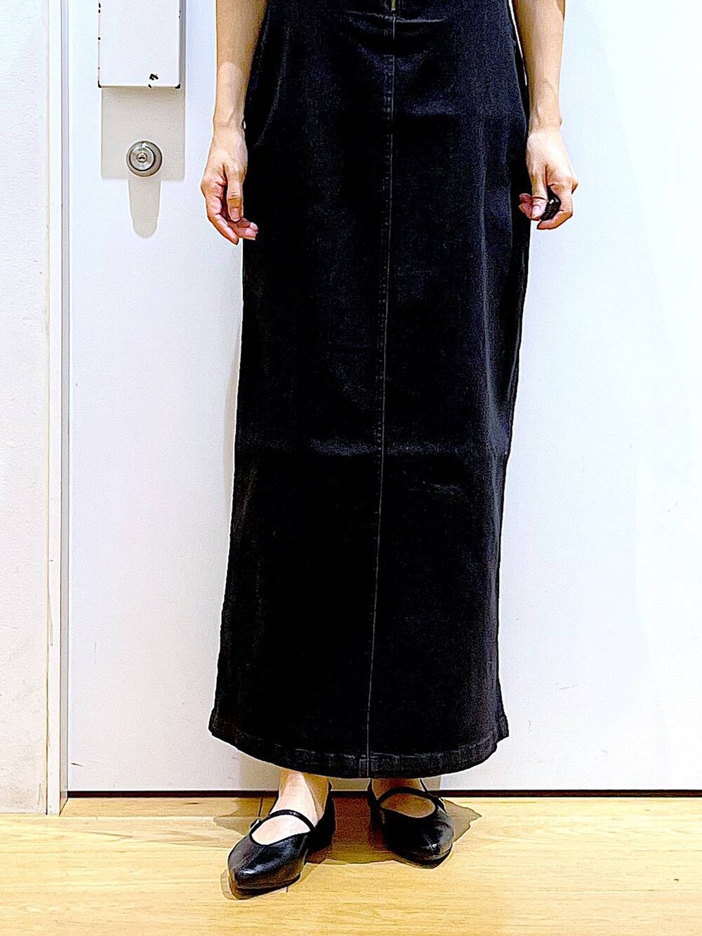 グレー系のジャンパースカート、ブラック系のパンプス、ベージュ系のショルダーバッグを着用したレディースの夏コーディネートの8枚目の写真