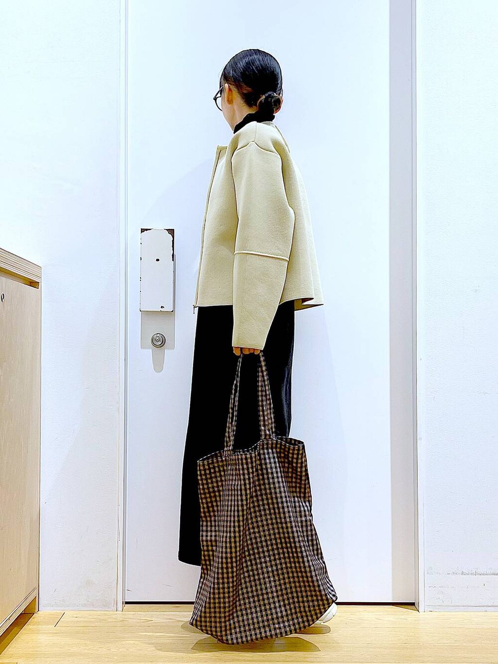 グレー系のジャンパースカート、ブラック系のTシャツ/カットソー、その他のトートバッグを着用したレディースの冬コーディネートの3枚目の写真