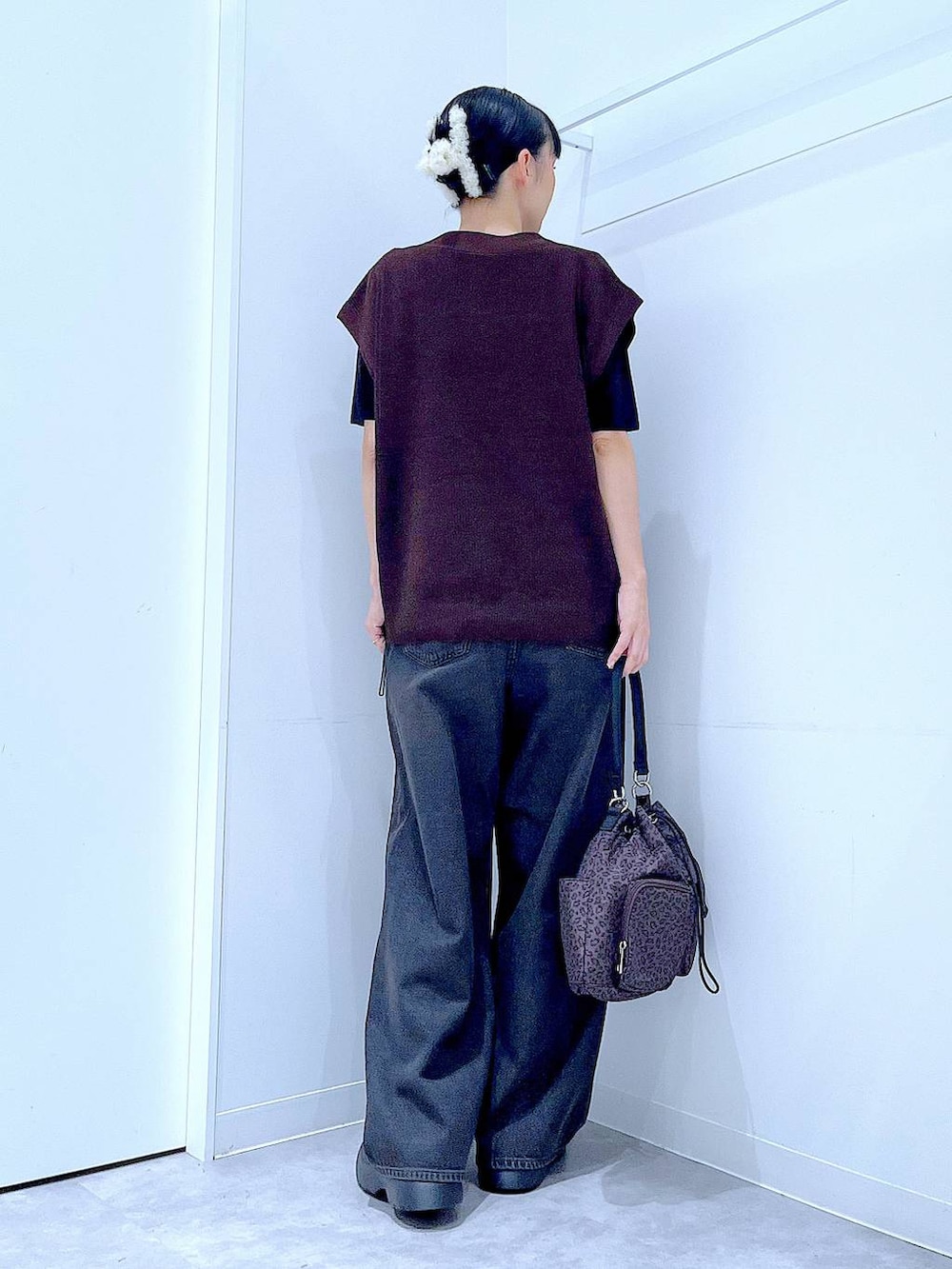 ブラック系のデニムパンツ、その他のハンドバッグ、ブラック系のTシャツ/カットソーを着用したレディースの秋コーディネートの5枚目の写真