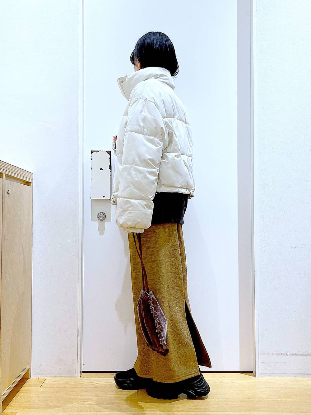 ベージュ系のブルゾン、ブラウン系のショルダーバッグ、ブラック系のブーツを着用したレディースの冬コーディネートの3枚目の写真