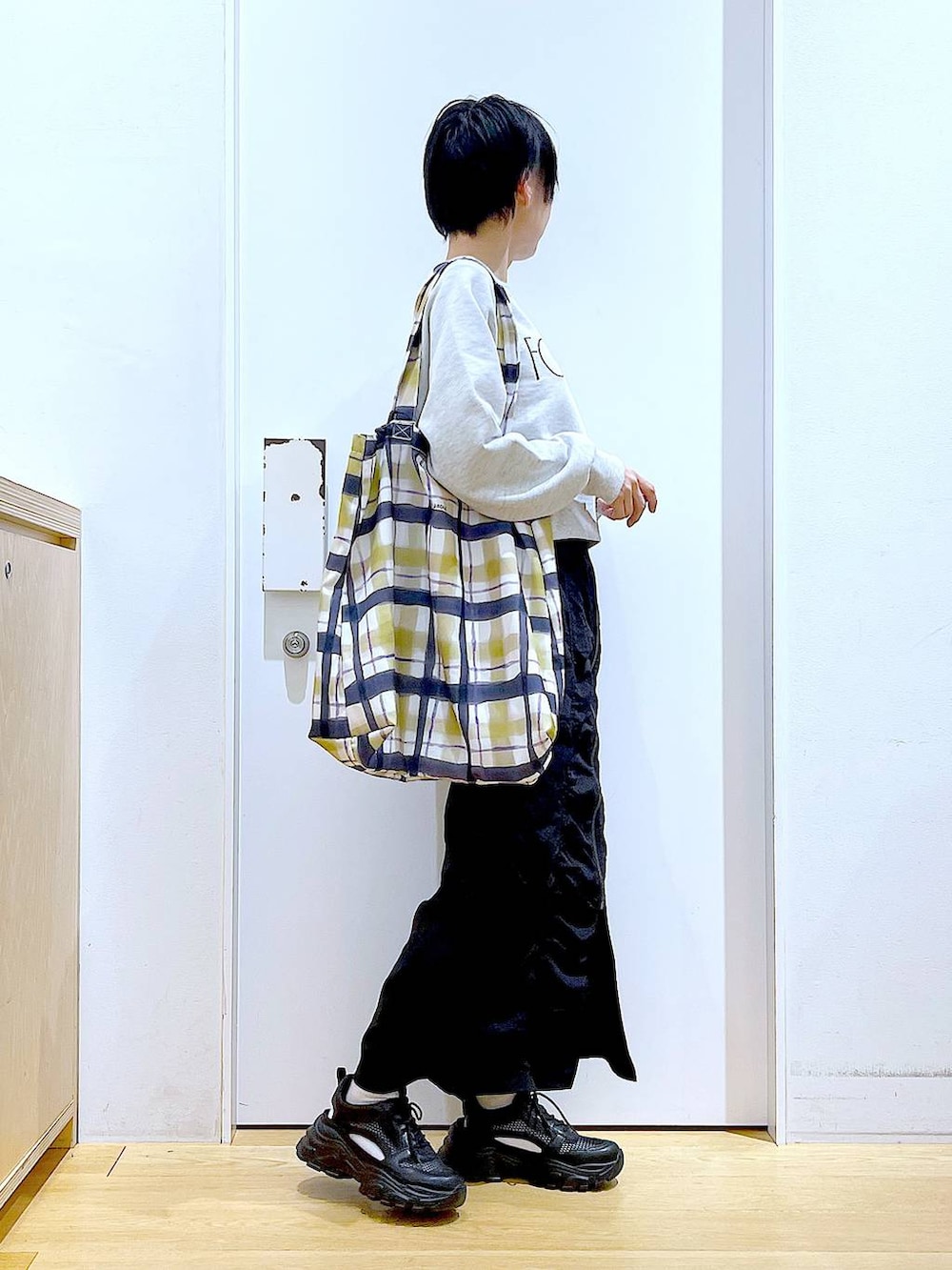 ブラック系のスカート、ブラック系のスニーカー、その他のトートバッグを着用したレディースの春コーディネートの4枚目の写真