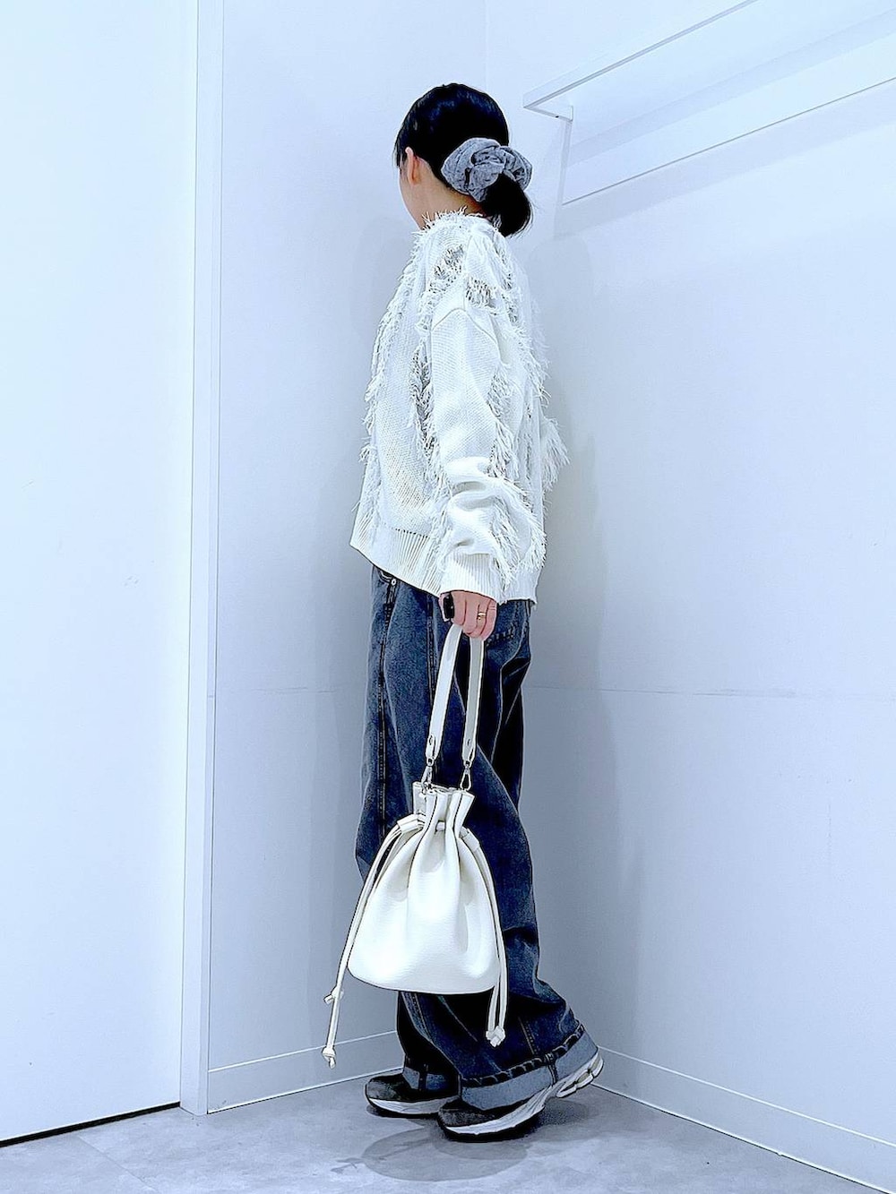 ブラック系のTシャツ/カットソー、ブラック系のデニムパンツ、ホワイト系のショルダーバッグを着用したレディースの春コーディネートの3枚目の写真