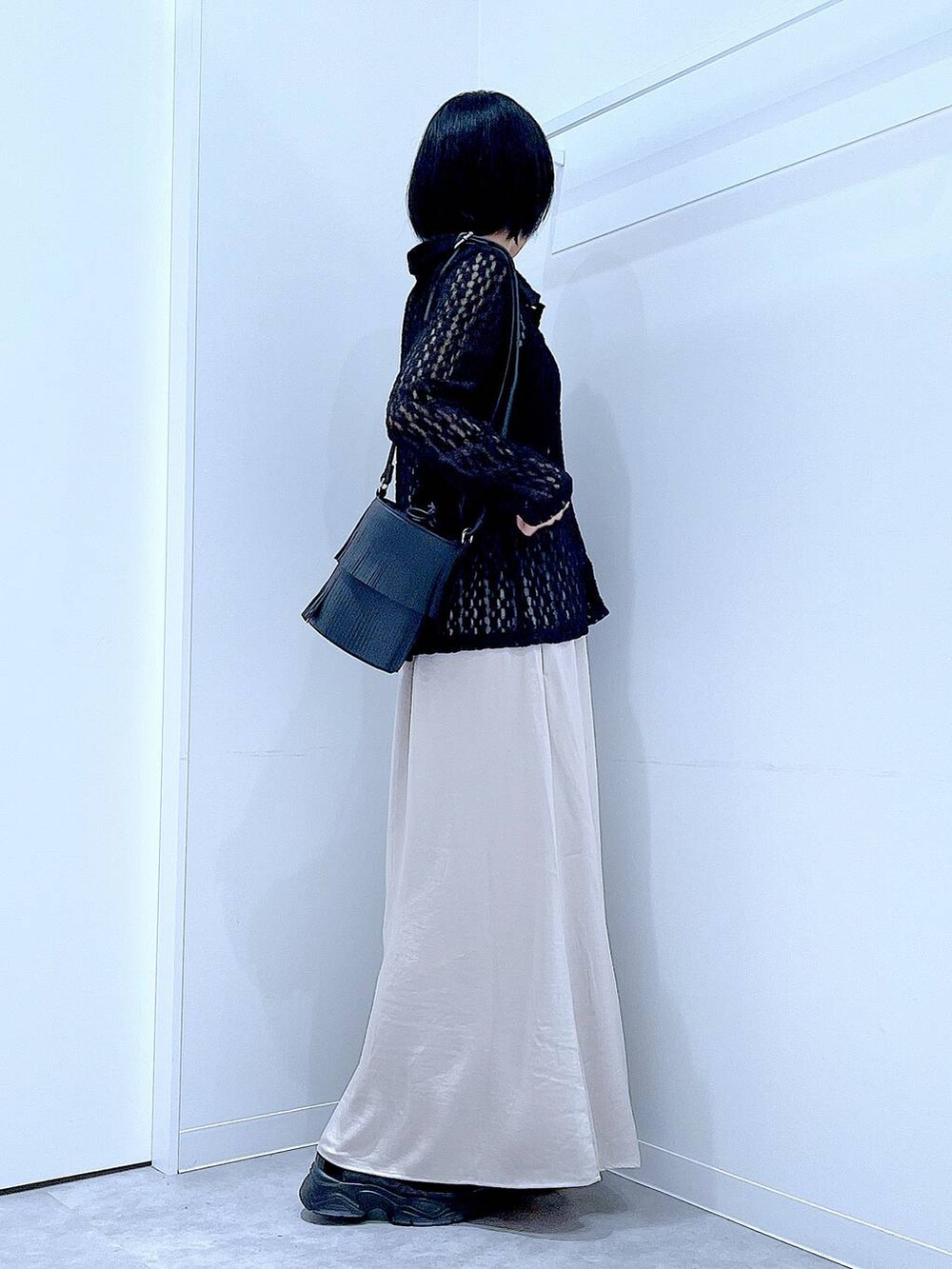 ブラック系のローファー、ブラック系のショルダーバッグ、ベージュ系のスカートを着用したレディースの秋コーディネートの4枚目の写真